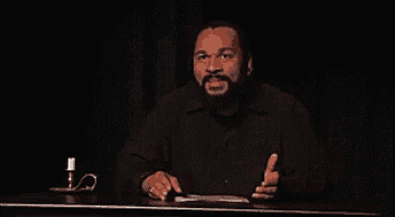 a man sitting at a table with the words de quoi tu m'parles written on the screen