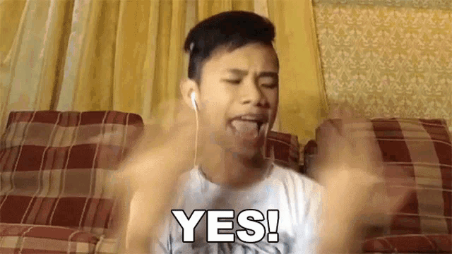 a young man wearing ear buds says yes