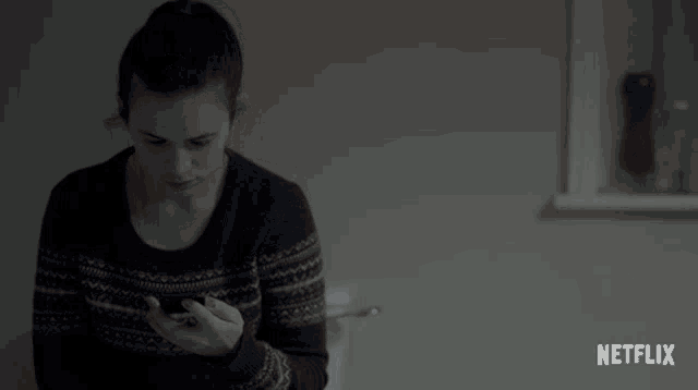 a woman talking on a cell phone with a netflix logo in the background