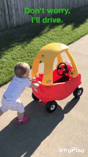 a child pushes a little tikes car down a sidewalk