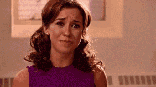 a woman in a purple dress is making a sad face .