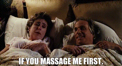 a man and a woman are laying in bed and the man is asking the woman if she massages him first .