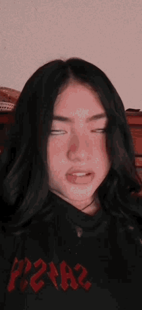 a girl wearing a black shirt with red letters that says p2na2
