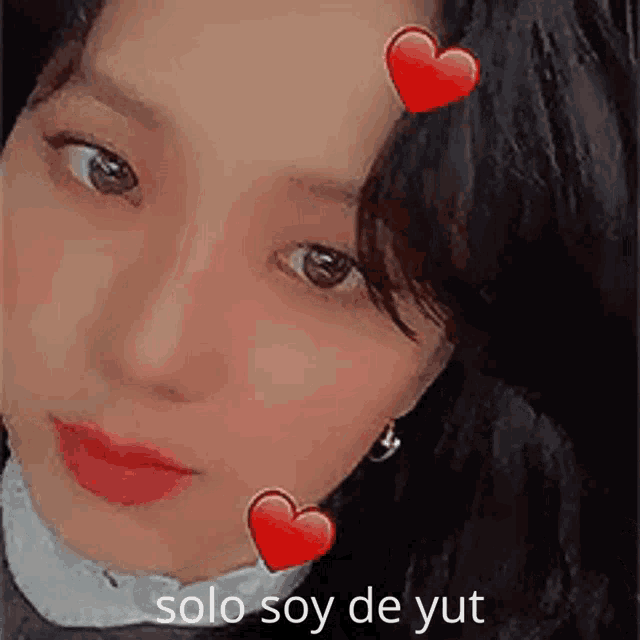 a close up of a woman 's face with hearts on her forehead and the words solo soy de yut written below her
