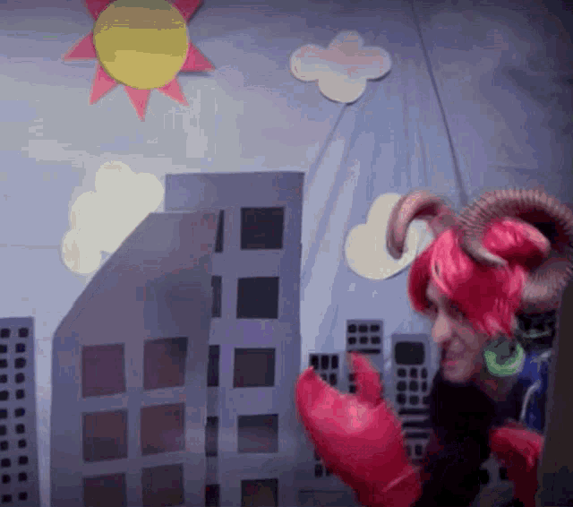 a man in a red wig and horns is standing in front of a city scene
