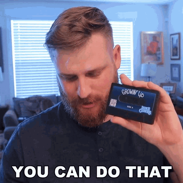 a man is holding a cassette tape that says grown up on it