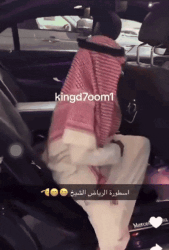 a man is sitting in the back seat of a car with kingd7zoom1 written on the bottom