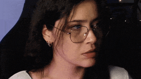 a close up of a woman wearing glasses making a funny face