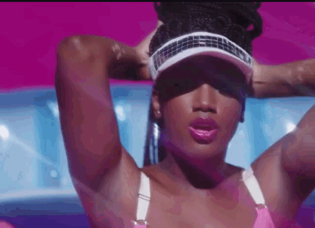 a woman wearing a pink bra and a white visor
