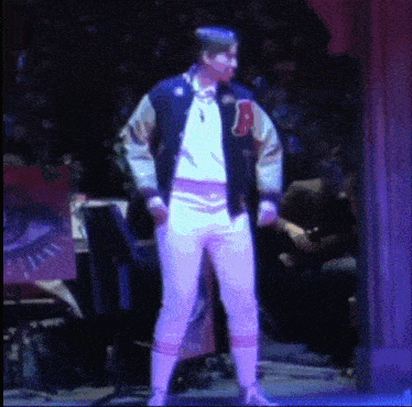 a man in a varsity jacket has the letter a on his arm