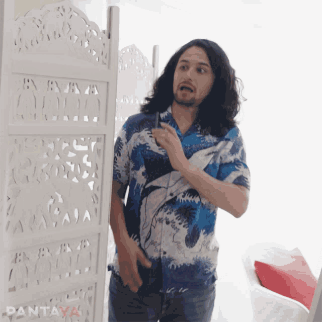 a man in a blue shirt is standing in front of a white screen with pantaya written on it