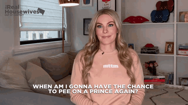 a woman standing in front of a couch wearing a sweatshirt that says mtm