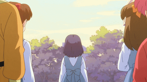 a girl with a blue bow on her back is standing in a crowd