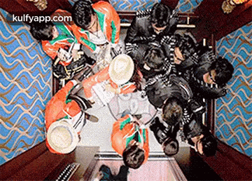 a group of people are sitting in an elevator looking down at each other .