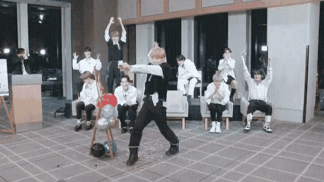 a group of young men are dancing in a room .