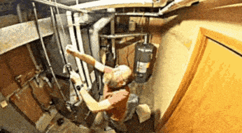 a man is working on a pipe in a basement