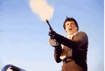 a man in a suit and tie is holding a flamethrower up in the air