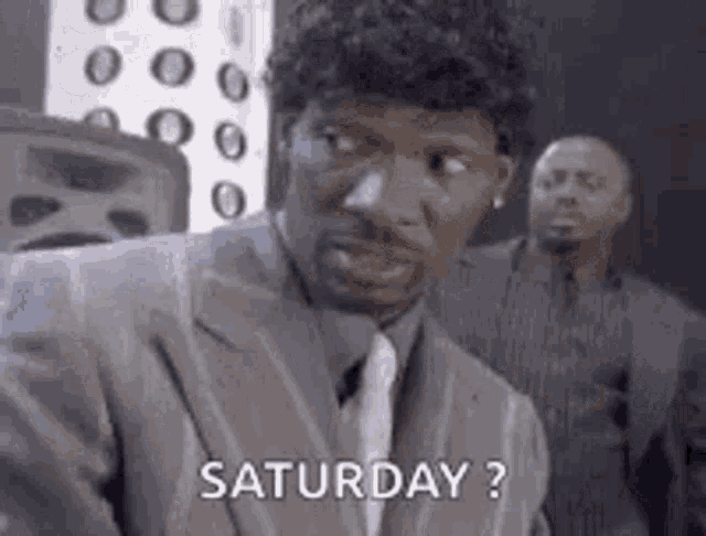a man in a suit and tie is asking , `` saturday ? '' in a black and white photo .
