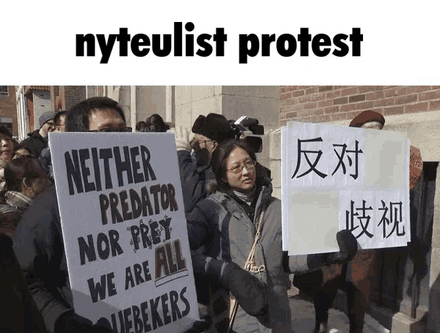 a group of people holding signs including one that says neither predator nor prey we are all