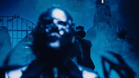 a man in a top hat stands in the dark