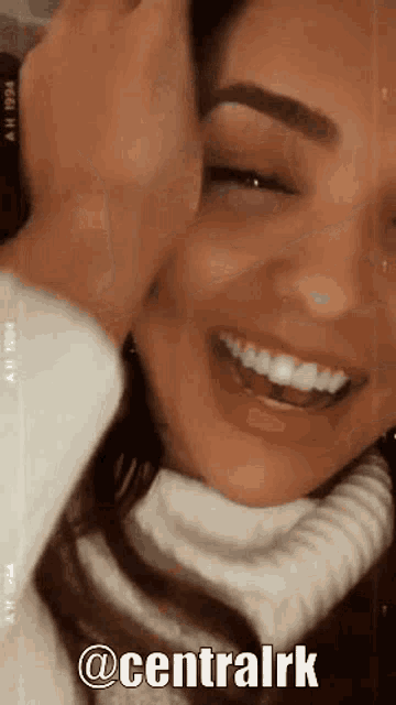 a woman in a white sweater is smiling with the words centralrk written on the bottom