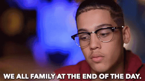 a young man wearing glasses and a red shirt says we all family at the end of the day