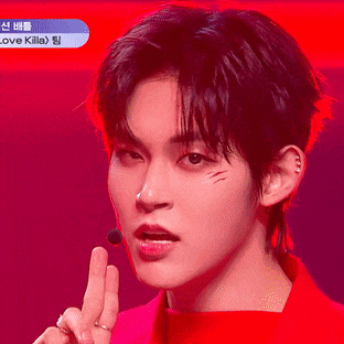 a young man wearing a red shirt is giving a thumbs up