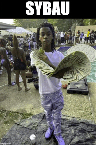 a young man is holding a large stack of money in front of a crowd and the word sybau is on the bottom
