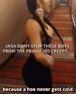 a woman in a black dress is dancing in a hallway with a caption .
