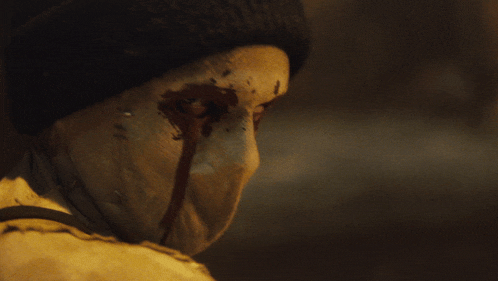 a close up of a person 's face with blood coming out of their eyes