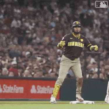 a baseball player in a san diego uniform is standing on the base .