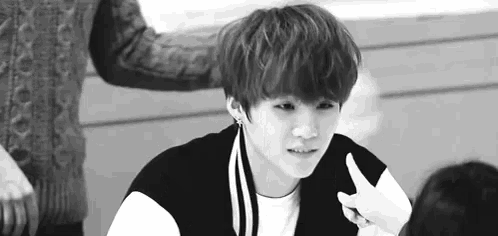 a black and white photo of a young boy giving a thumbs up sign .