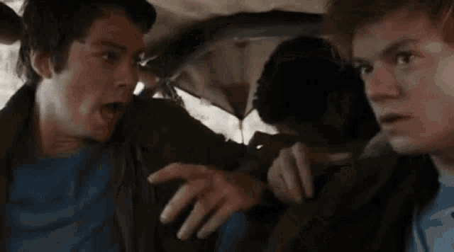 a man is talking to another man in a car .
