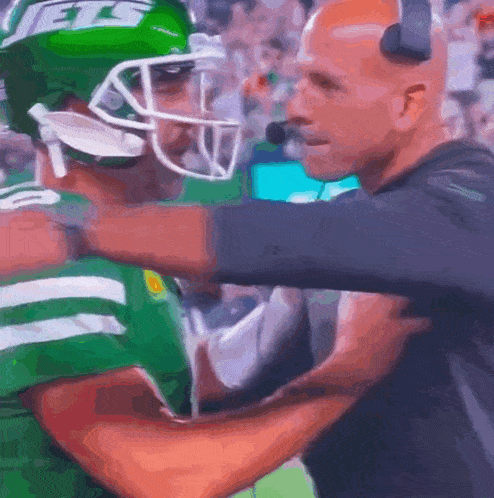 a man wearing a helmet that says jets on it talks to another man