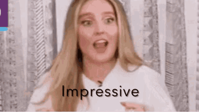 a woman is making a funny face with her mouth open and the word impressive is written on the screen .