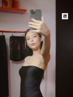 a woman in a black dress is taking a selfie