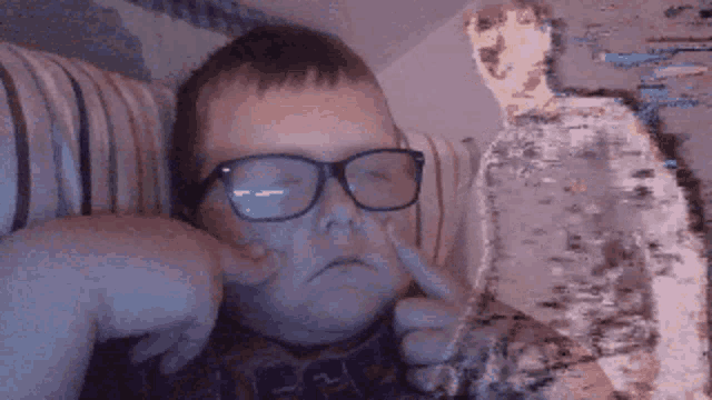 a boy wearing glasses is making a face