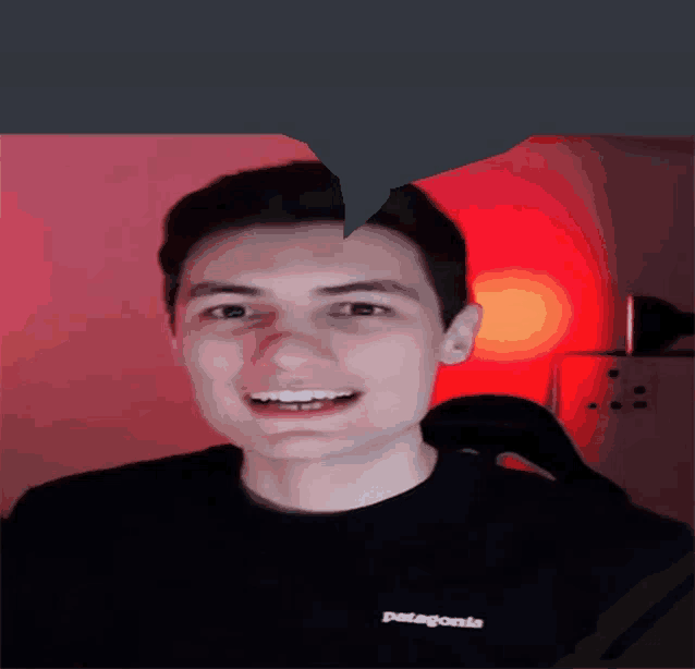 a man wearing a black patagonia shirt smiles