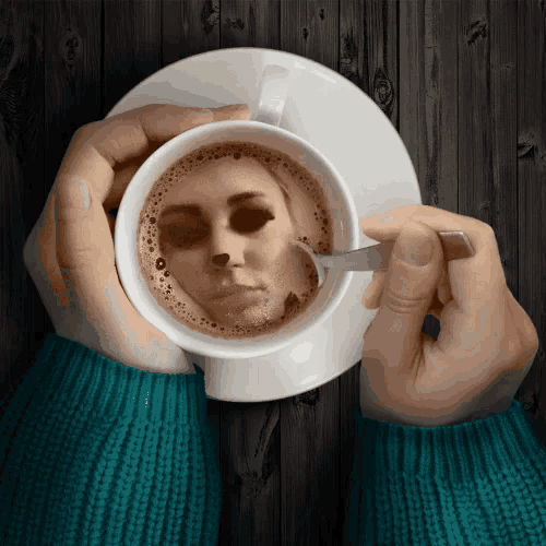 a person holding a cup of coffee with a picture of a woman 's face on it