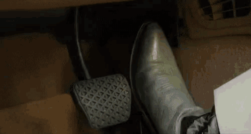 a close up of a person 's foot on a car pedal .
