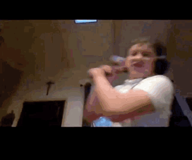 a person wearing headphones is singing into a microphone in a room .