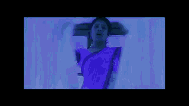 a woman in a purple sari is standing next to a man in a white shirt .