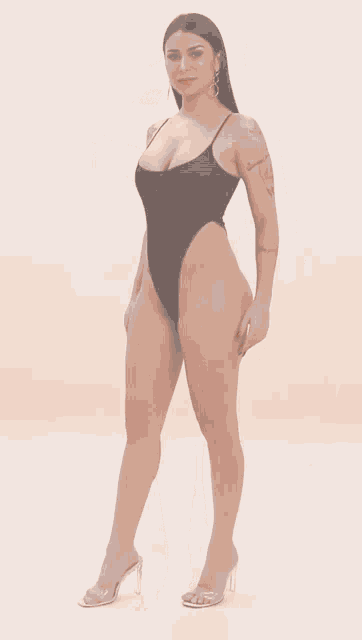 a woman in a black bodysuit has a tattoo on her back that says " l' amour est de toute part "