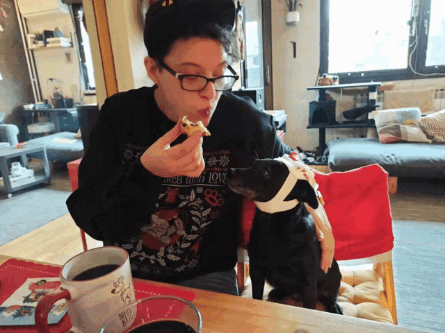a person wearing a black sweater that says " more than love " is eating something