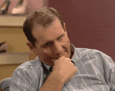 a man in a blue and white striped shirt has his hand to his mouth