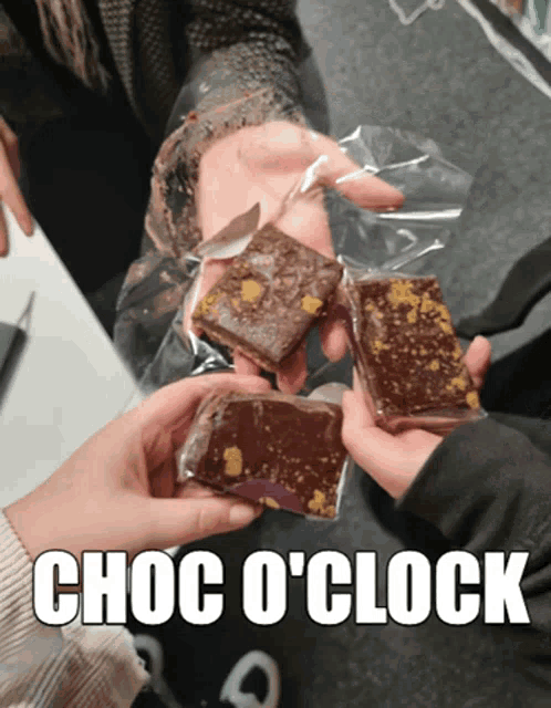 a person holding a piece of chocolate that says choc o'clock on it