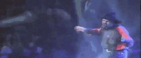 a man in a red shirt and blue jeans is dancing on a stage .