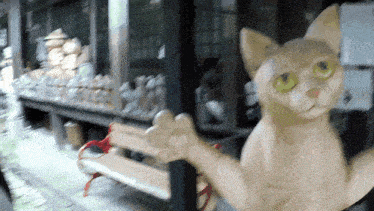 a statue of a cat with green eyes is standing next to a bench