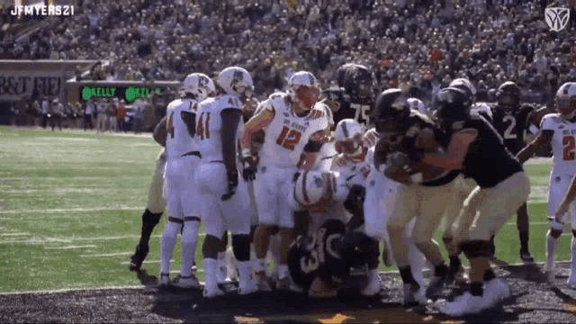 a football player with the number 12 on his jersey is surrounded by other players on the field