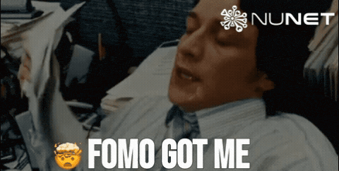 a man in a suit and tie says " fomo got me " in front of a nunet logo